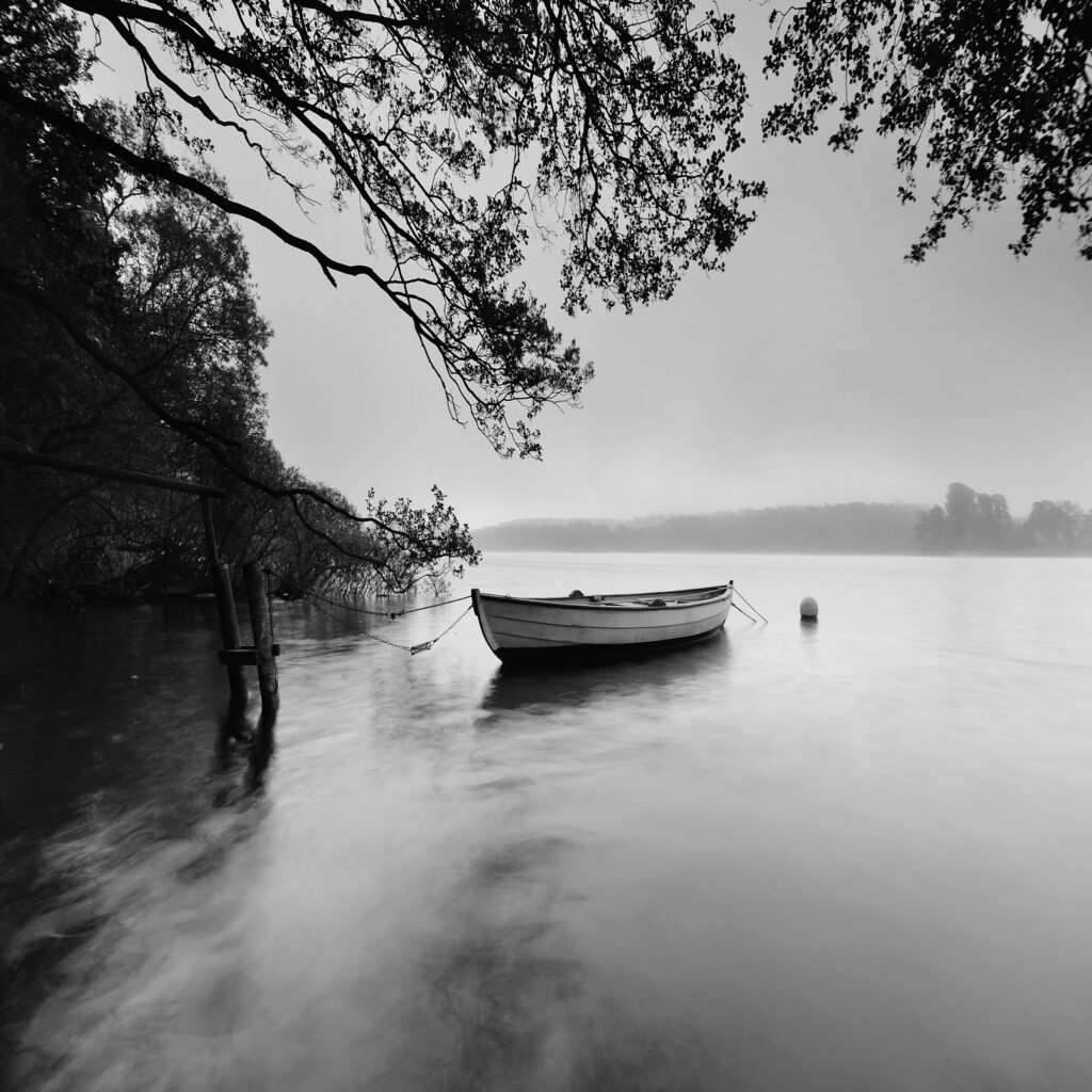 A black and white photo of a boat on a river